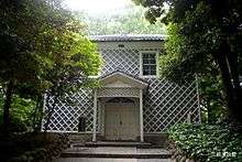 Building with latticework exterior and white double doors