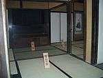 Interior of a Japanese house with tatami floor and sliding doors.