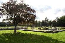 A photograph showing the ruins of the abbey and the memorial stone for Cardinal Wolsey