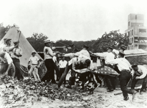  Police with batons confront demonstrators armed with bricks and clubs. A policeman and a demonstrator wrestle over a U.S. flag.