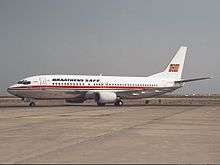 Boeing 737-400 with a white body, metallic belly and a red cheatline