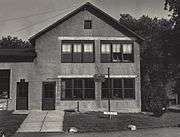 A shingled two-story building and driveway