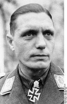 A man wearing a military uniform with an Iron Cross displayed at the front of his uniform collar.