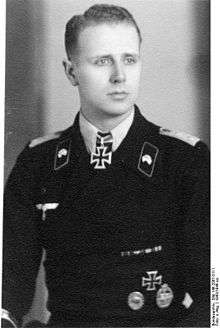 A man wearing a military uniform with an Iron Cross displayed at the front of his uniform collar.