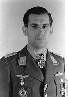 A man wearing a military uniform with an Iron Cross displayed at the front of his uniform collar.