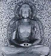 Front view of a cross-legged seated statue, showing the meditation gesture (Dhyāna Mudrā) with both hands placed on the lap, palms facing upwards.