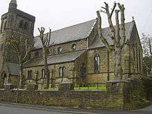 A church with a flat-topped tower and a stair turret