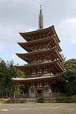Five-storied wooden pagoda with white walls and vermillion red beams.