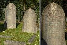 Two granite headstones in a grassy cemetery