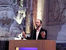 photograph of a man speaking from a pulpit