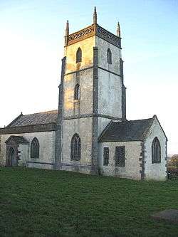 Whitewashed building with square tower.