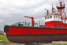 Photograph of Fireboat No. 1 in drydock as a museum ship. Several water cannons stand prominently at the bow, atop the bridge, and in the crow's nest.