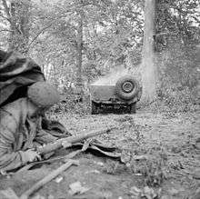 Soldier looks on at damage burning vehicle