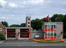 A grey and red, very angular and clean looking prefabricated building of two bays.