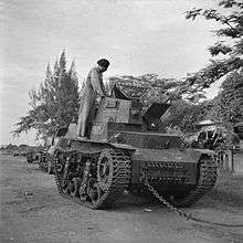 A damaged Marmon-Herrington CTLS with an Indonesian soldier inspecting it