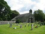 A simple small church seen from the northwest with a west double bellcote