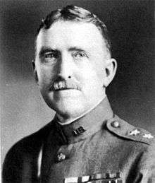 Man facing forward in high neck uniform with ribbon bars on