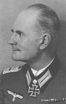 An elderly man wearing a military uniform with various military decorations displayed at the front of his uniform collar.