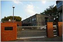 Older grey building seen through a gate