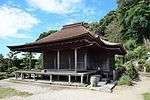 A wooden building with a wide front veranda.