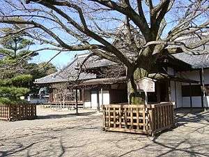 A wooden house with white walls and a gabled roof.