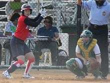 batter prepares for pitch with catcher squats behind her