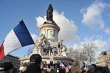 Place de la République statue column with large French flag