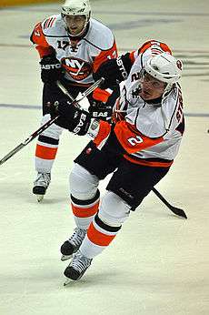 Mark Streit shooting the puck on the ice with another player right behind him.