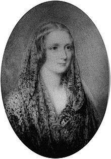 Black-and-white oval portrait of a woman wearing a shawl and a thin circlet around her head.