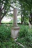 Column memorial in long grass.