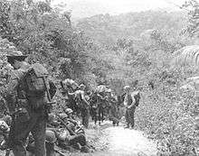 Soldiers that are part of Merrill's Marauders, resting alongside a jungle trail in Burma