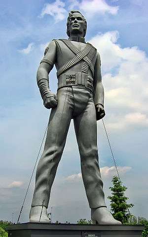Silver-colored statue of Jackson standing up with his arms bent inward and both legs spaced apart.