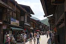 Small street lined by wooden two-storeyed houses.