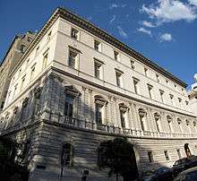 Angular view of a big building with three arched windows on the first floor and three arched doors on the ground floor.