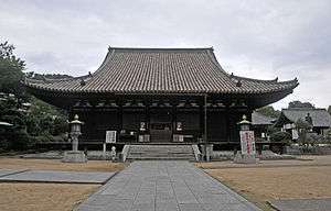 Wooden building with a hip-and-gable roof.