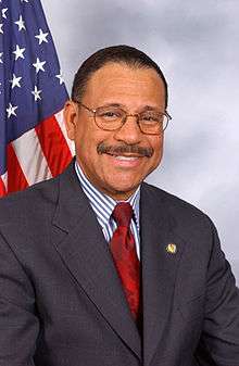 man in business suit, American flag in background