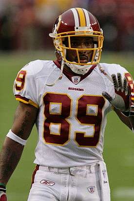 A dark-skinned man wearing American football attire