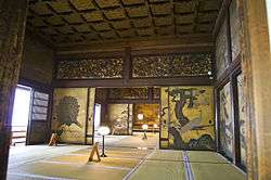 Three tatami matted rooms separated by sliding doors decorated with bird and plant motifs.