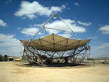 A horizontal parabolic dish, with a triangular structure on its top.