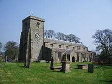 A plain stone church with a clerestory and a west tower with a plain parapet.