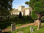 A stone church seen from the southeast with a central tower surmounted by a plain parapet