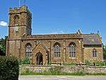 Yellow stone building with square tower.