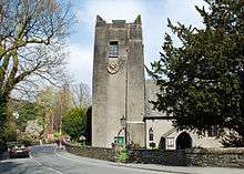 The rendered tower of a church and part of the nave