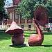 Two sculptures, red in colour, with trumpet-like top portions.