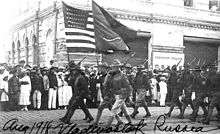 Soldiers parading with two flags, one American